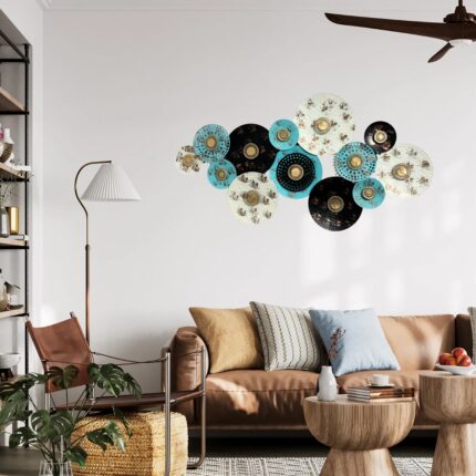 Modern circular metal wall art featuring multiple intersecting orbits in a bronze finish, styled above a living room sofa